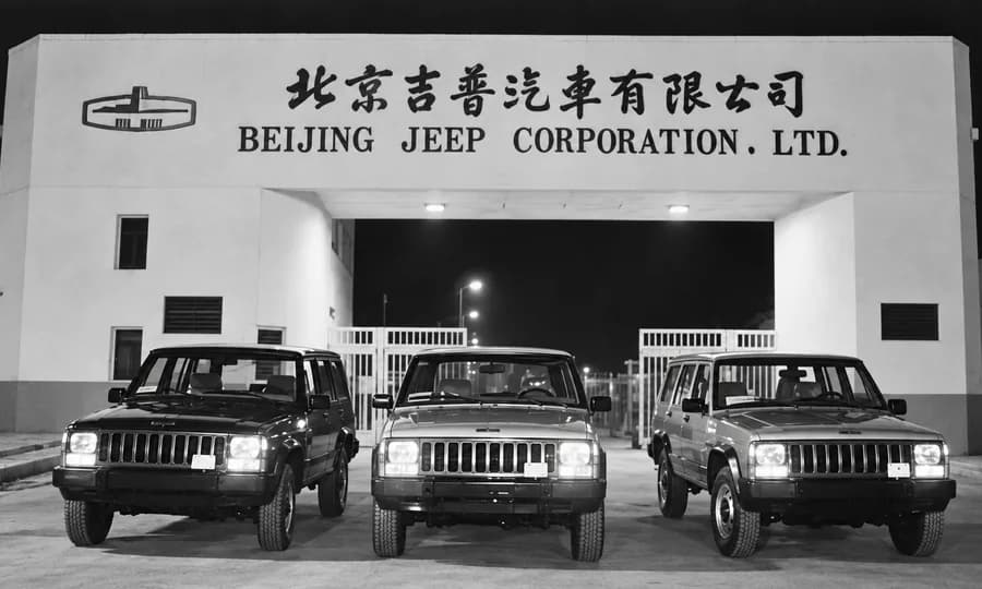 Fachada da Beijing Jeep Corporation com três jipes
