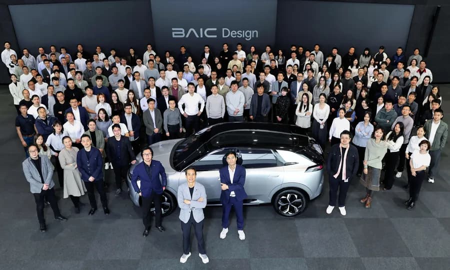 Equipe da BAIC reunida ao redor de um veículo